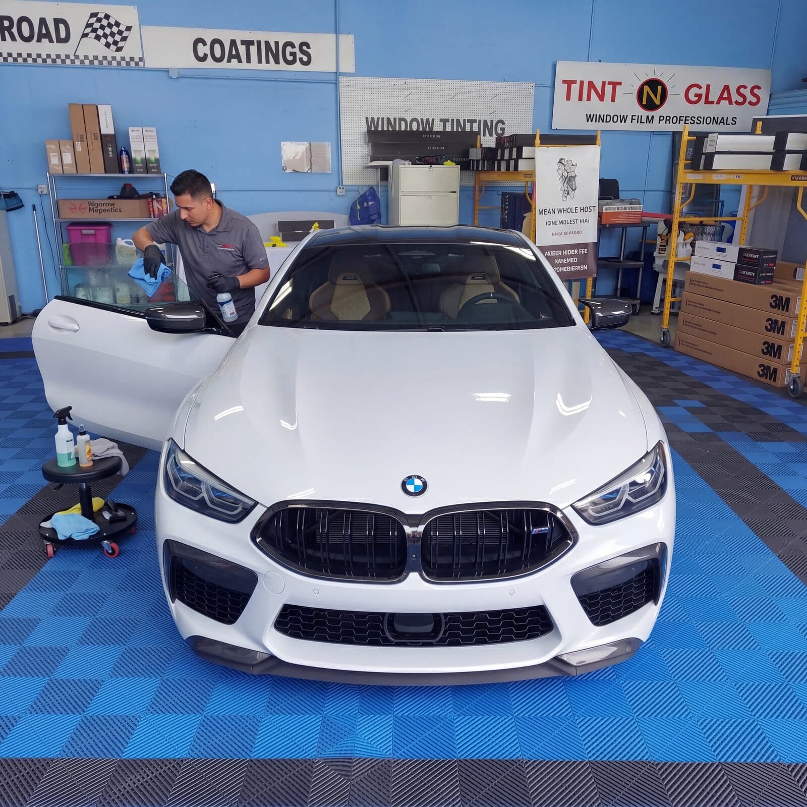 Prepping a white BMW in the bay before the ceramic tint install begins.